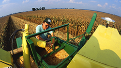 A picture of farmer on a tracker in a field.